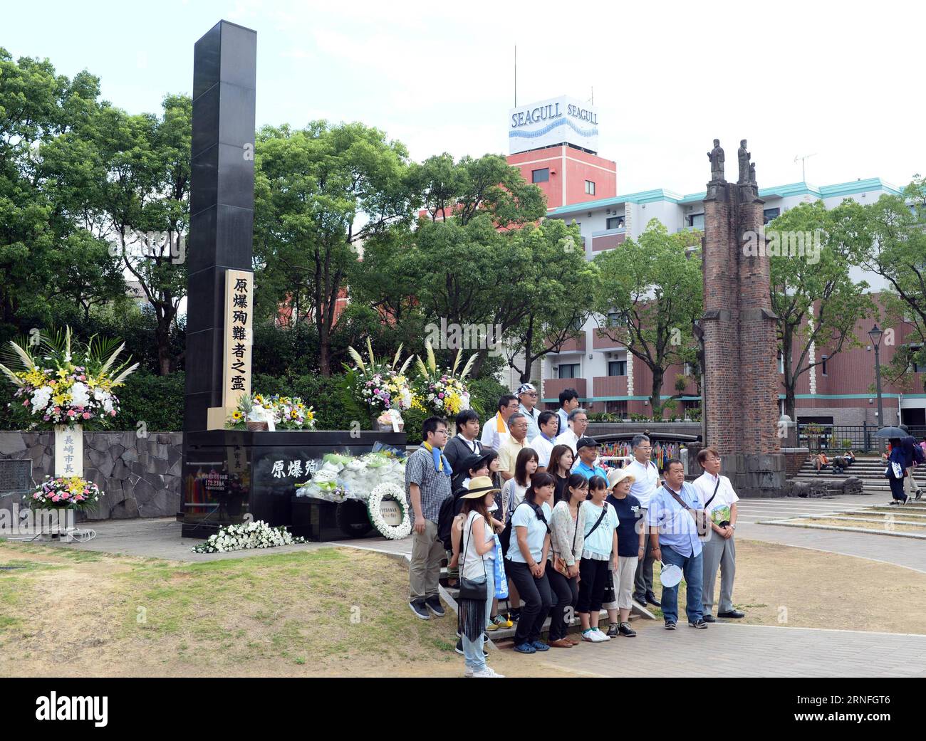 71. Jahrestag des Atombombenabwurfs auf Nagasaki (160809) -- NAGASAKI, Aug. 9, 2016 -- People pose for photos in front of the monument at the atomic bomb hypocenter to commemorate the 71st anniversary of U.S. atomic bombing, at the Peace Park in Nagasaki, on Aug. 9, 2016. To accelerate Japan s surrender in the World War II, the U.S. forces dropped two atomic bombs on Hiroshima and Nagasaki respectively on Aug. 6 and 9, 1945. ) (syq) JAPAN-NAGASAKI-ATOMIC BOMBING-71ST ANNIVERSARY-COMMEMORATION MaxPing PUBLICATIONxNOTxINxCHN   71 Anniversary the Atombombenabwurfs on Nagasaki 160809 Nagasaki Aug Stock Photo
