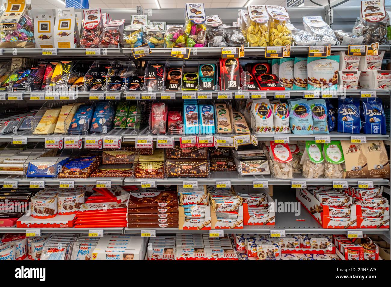 Italy - August 14, 2023: Bars of chocolates and chocolates in packs of various colours and various brands on the shelves for sale in an Italian superm Stock Photo