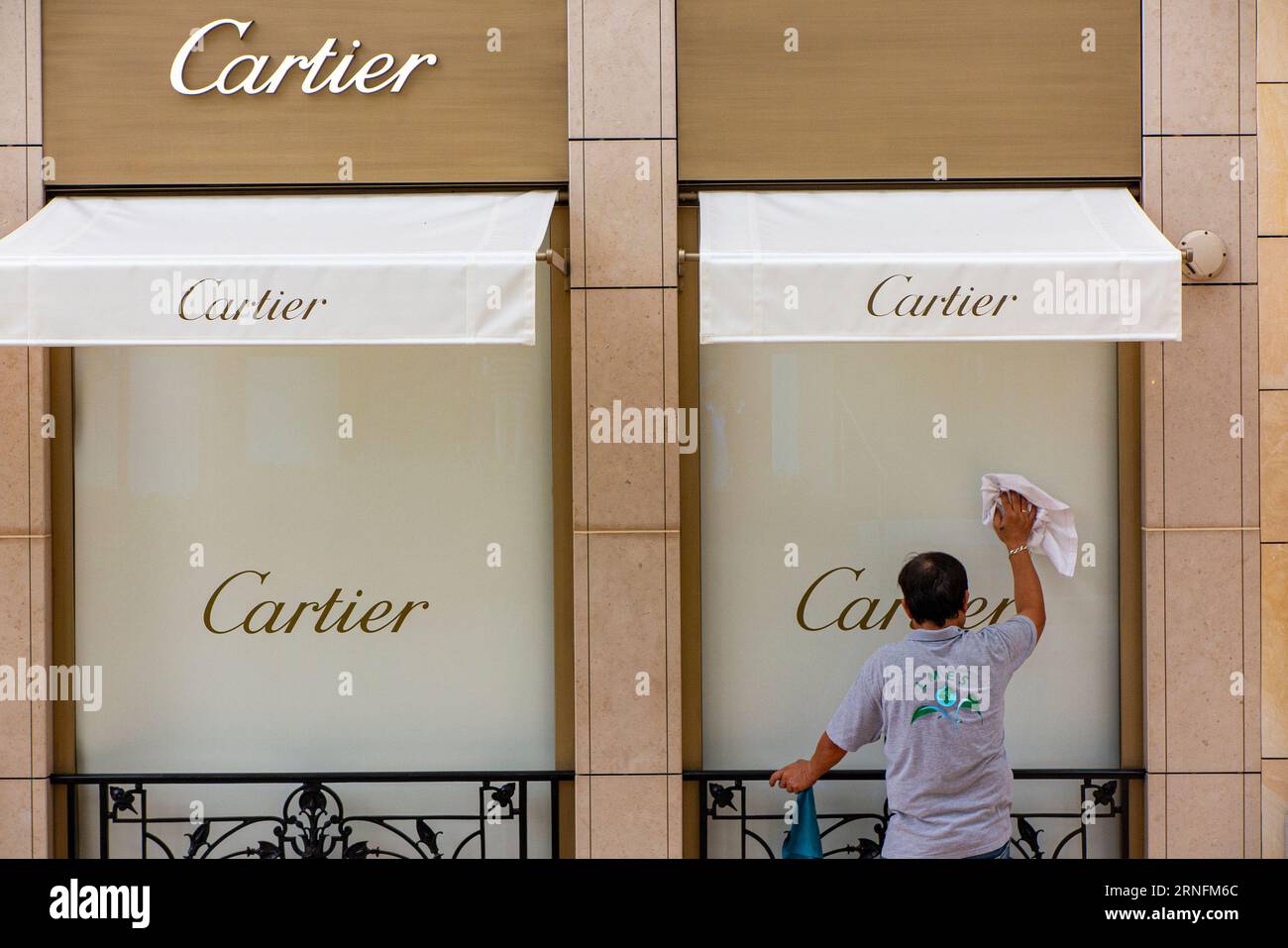 A man cleans the window of a Cartier shop in Monte Carlo, Monaco, France Stock Photo