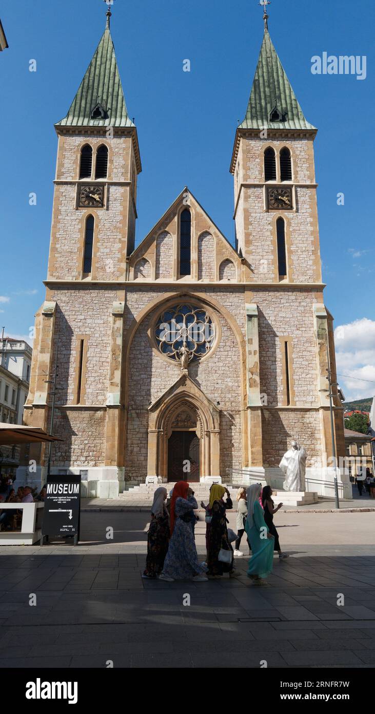 Muslim women in traditional clothing outside the Sacred Heart Cathedral Catholic Church in the City of Sarajevo on a summers day, September 01, 2023 Stock Photo