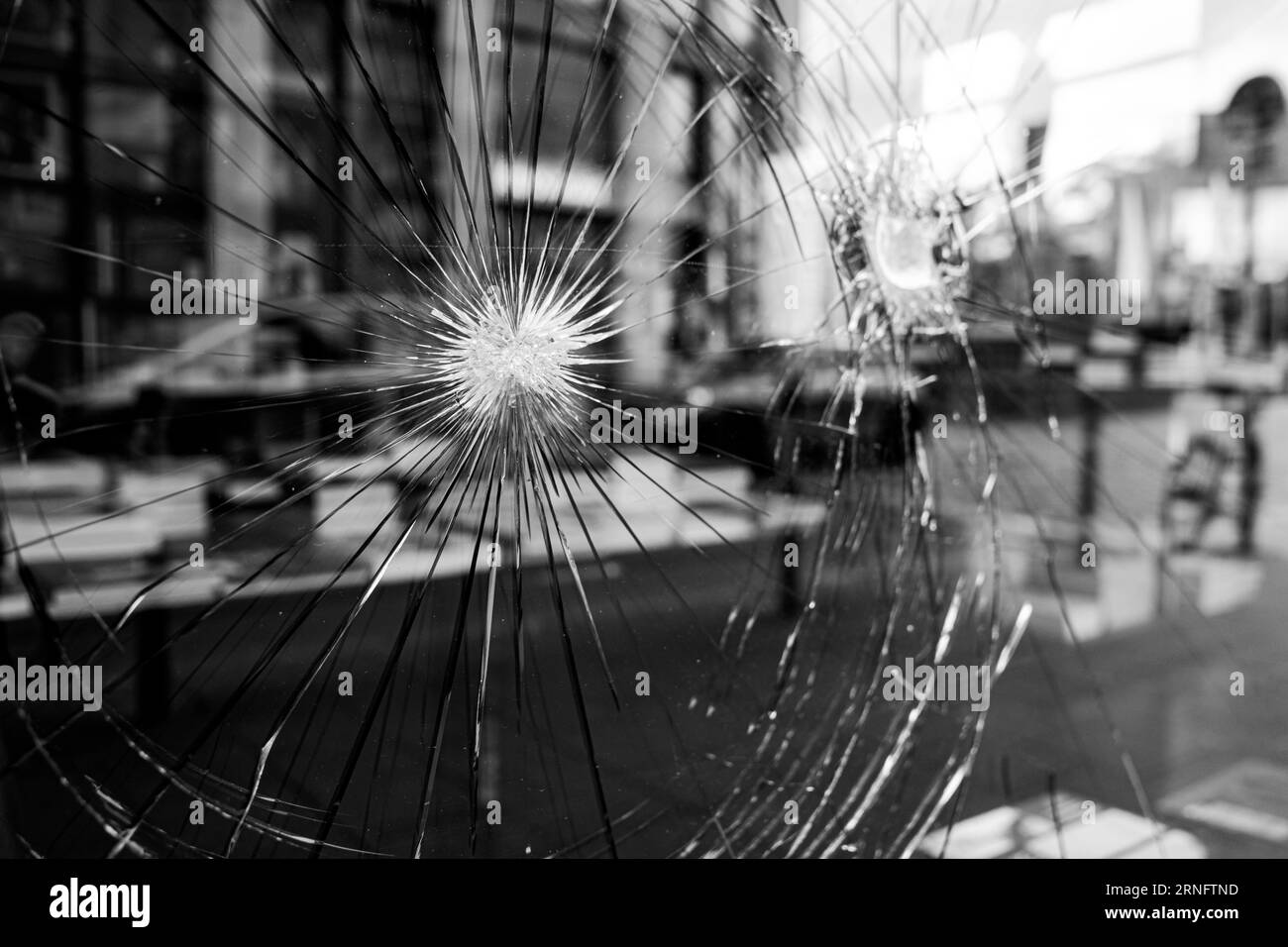 Black and white tone, blur city street reflection on broken crack glass window. Stock Photo