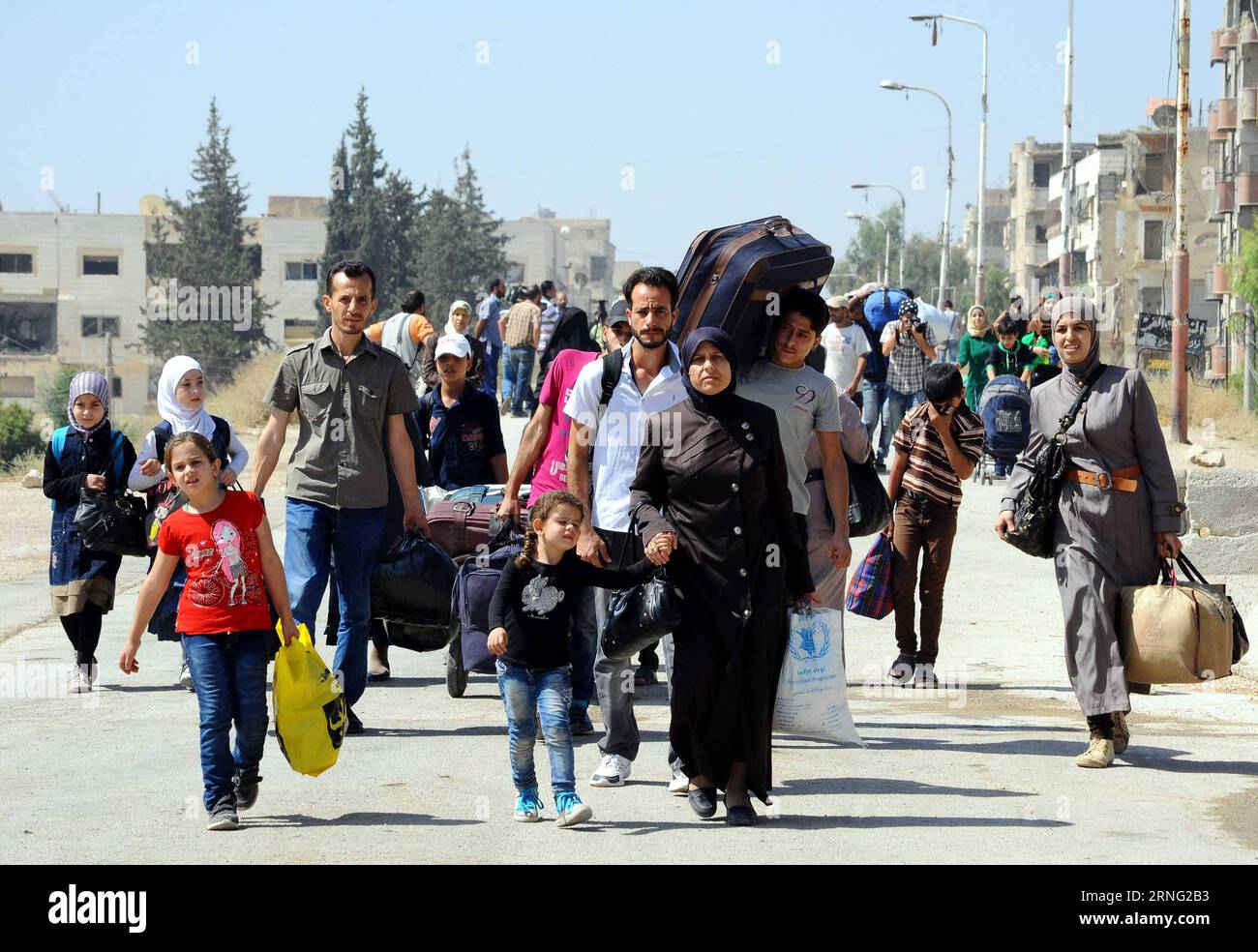 Bilder des Tages Syrien: Menschen flüchten aus Muadamiyeh bei Damaskus (160902) -- DAMASCUS, Sept. 2, 2016 -- Syrian civilians carry their belongings to evacuate from the rebel-held town of Muadamiyeh, in rural Damascus, capital of Syria, on Sept. 2, 2016. Nearly 300 civilians, who were originally from the town of Daraya for refuge, were evacuated from Muadamiyeh to government-controlled shelters in southern Damascus. SYRIA-DAMASCUS-CIVILIANS-EVACUATE-REBEL-HELD-TOWN Ammar PUBLICATIONxNOTxINxCHN   Images the Day Syria People flee out  at Damascus 160902 Damascus Sept 2 2016 Syrian civilians Ca Stock Photo