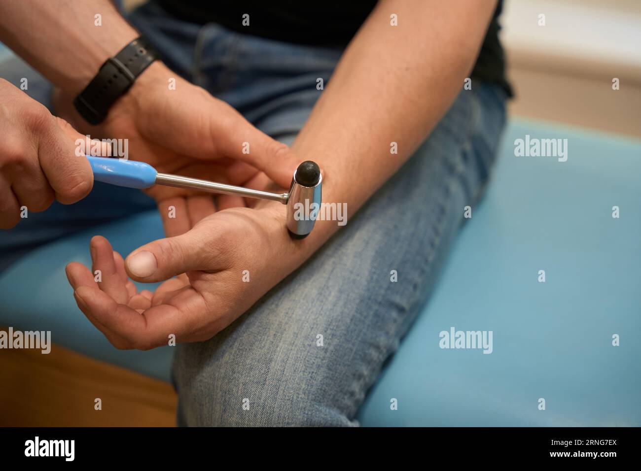Cropped photo of patient seated on examination couch while doctor