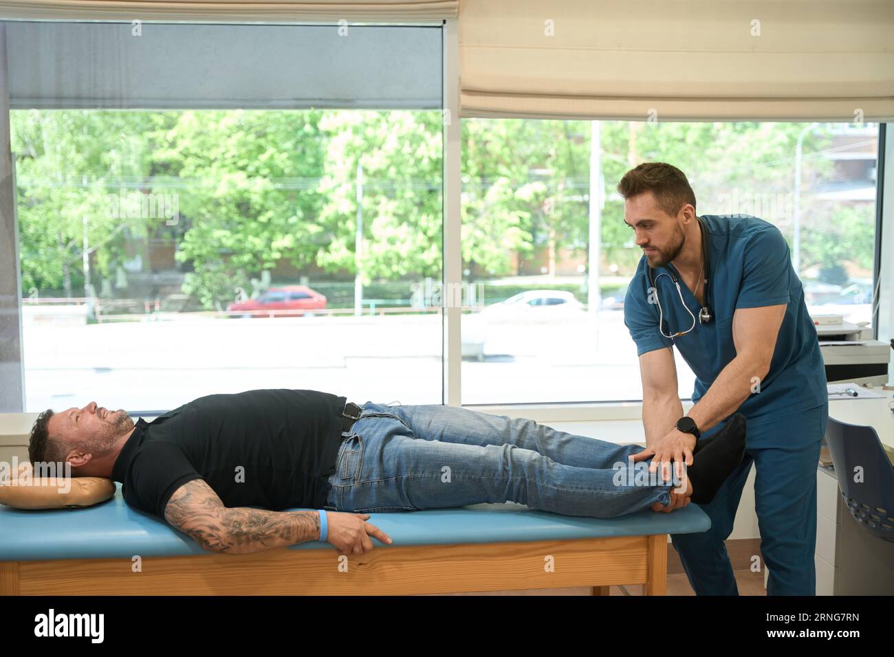 Physical therapist assessing lower extremity muscle strength in patient