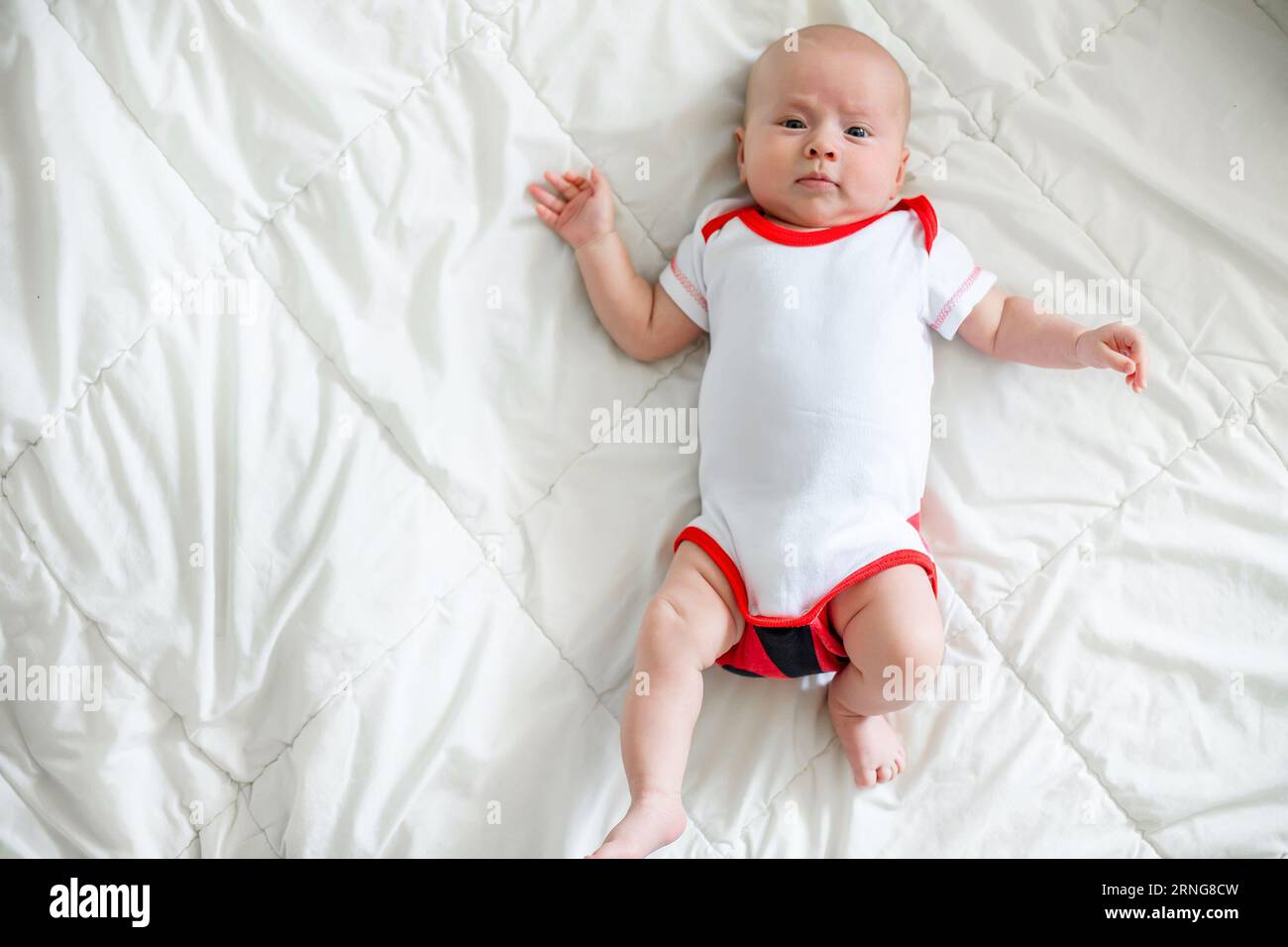 The 2 month old baby looks content sleeping on a white blanket in the crib. Home Comfort Stock Photo Alamy