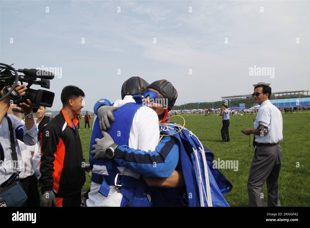 (160925) -- PYONGYANG, Sept. 25, 2016 -- A foreign visitor hugs a local parachutist coach after their landing during an international air show in Wonsan, the Democratic People s Republic of Korea (DPRK), on Sept. 25, 2016, the second day of the international air show. The Wonsan International Friendship Air Festival, the first of its kind in the DPRK, runs from Saturday through Sunday at Kalma International Airport, which was redesigned and reconstructed from a military airfield to promote tourism. ) (cl) DPRK-WONSAN-INTERNATIONAL AIR SHOW ZhuxLongchuan PUBLICATIONxNOTxINxCHN   Pyongyang Sept Stock Photo