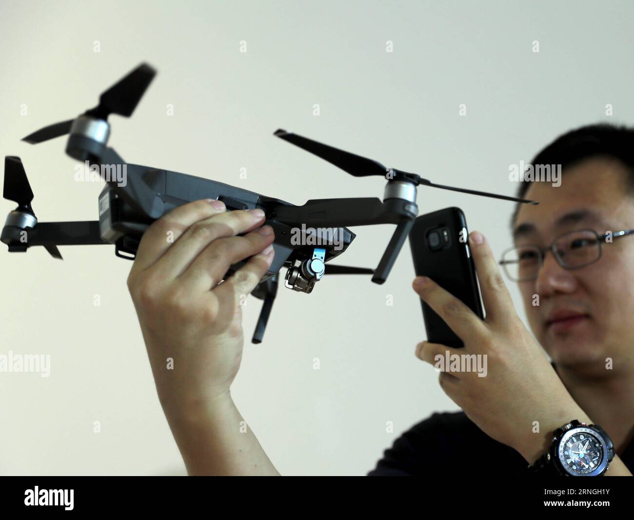 (160929) -- BEIJING, Sept. 29, 2016 -- A journalist takes photo of the DJI Mavic Pro during a press conference in Beijing, capital of China, Sept. 29, 2016. The Mavic Pro is a small yet powerful drone released by DJI, a Chinese technology company manufacturing unmanned aerial vehicles for flying cameras. DJI Mavic Pro has a stabilized camera with 12 megapixels and a new transmission system with 7 kilometers range. ) (mp) CHINA-BEIJING-DRONE-MAVIC PRO-PRESS CONFERENCE (CN) ChenxJianli PUBLICATIONxNOTxINxCHN   Beijing Sept 29 2016 a Journalist Takes Photo of The Dji  pro during a Press Conferenc Stock Photo