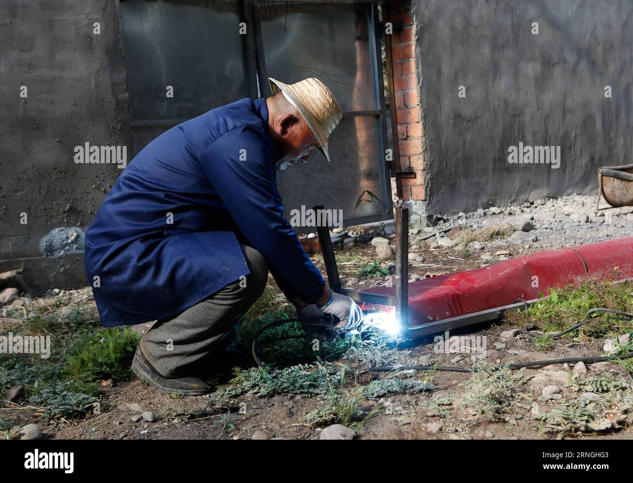 (160930) -- QILIAN, Sept. 30, 2016 -- Zhao Xuewen welds a food trough at a livestock-breeding cooperative in Gezidong Village of Zhamashi Township, Qilian County, northwest China s Qinghai Province, Sept. 28, 2016. Our life will get better and better , the 50-year-old Zhao Xuewen said while looking at his sheep on the hillside in Gezidong. His situation was not so good only a few years ago. In 2012, Zhao suffered a fracture to his leg as he repaired his house. Unfortunately, his wife had three operations in the same year. The successive misfortunes subjected the man of the Hui ethnic group a h Stock Photo