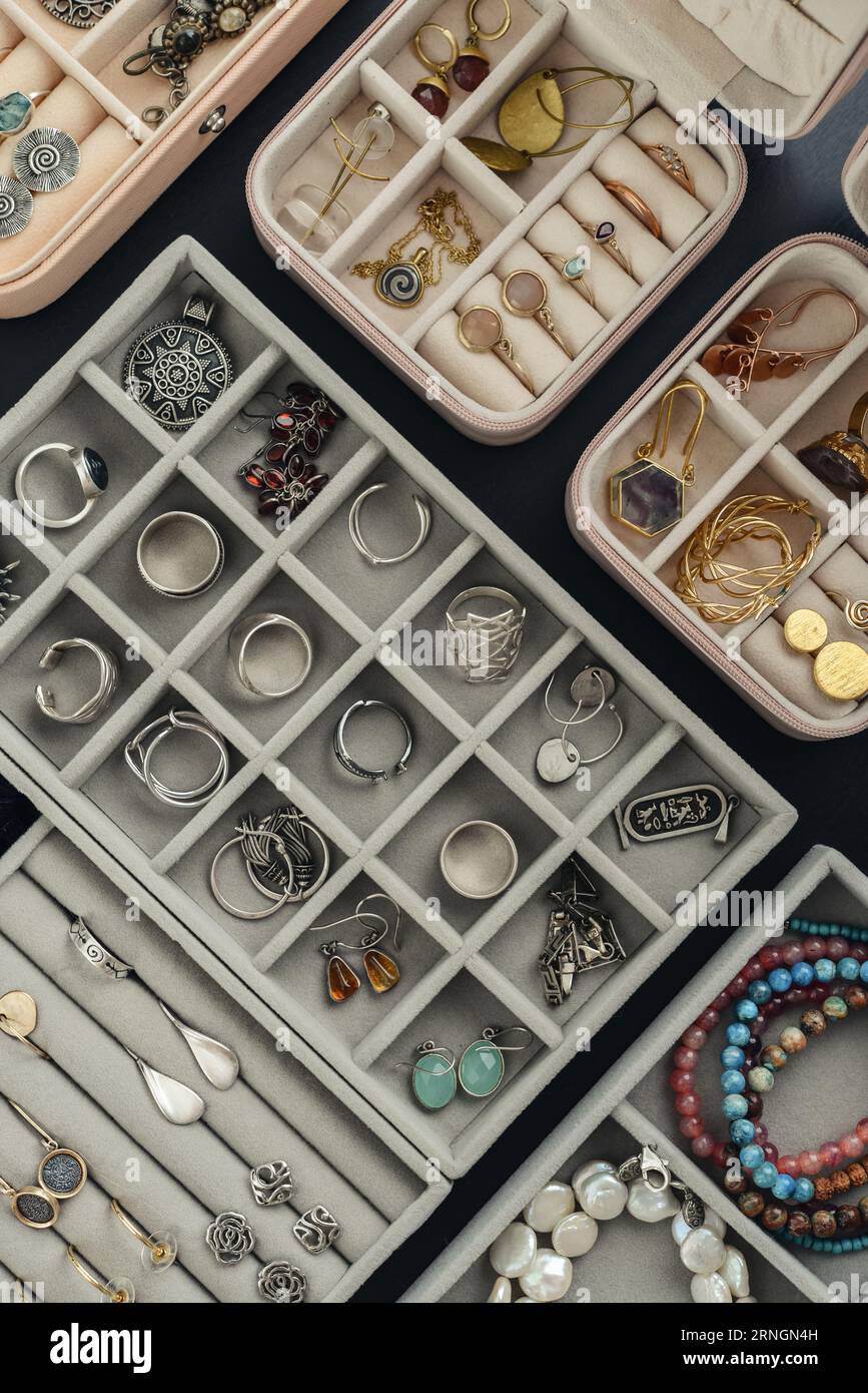 Grey velvet Jewelry  Organizer with different silver and gold rings, earings and bracelets, top view Stock Photo