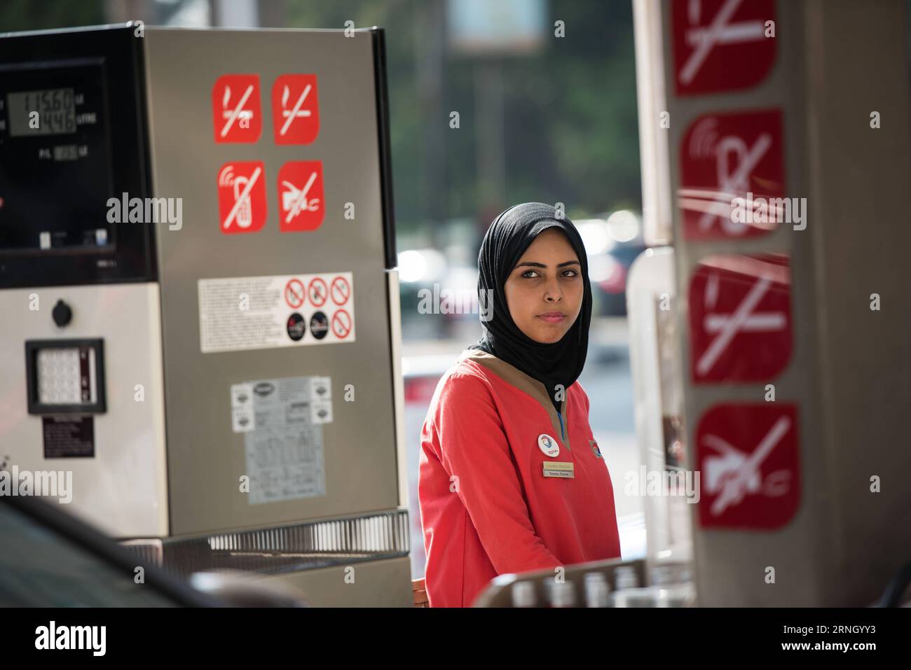 Ägypten - Weibliche Arbeitskräfte an einer Tankstelle in Kairo (161018) -- CAIRO, Oct. 18, 2016 -- A female employee serves a vehicle at a gas station in Maadi district of Cairo, Egypt, Oct. 17, 2016. Dressed in red buttonless shirt and black pants uniform, 24-year-old veiled Hadeer Ashraf looked confident and swift while holding the fuel pump nozzle gun to serve the vehicles lined up at Total gas station near the Nile Corniche Street in Maadi district southwestern the Egyptian capital city of Cairo. ) (yk) EGYPT-CAIRO-GAS STATION-FEMALE WORKERS MengxTao PUBLICATIONxNOTxINxCHN   Egypt Female W Stock Photo