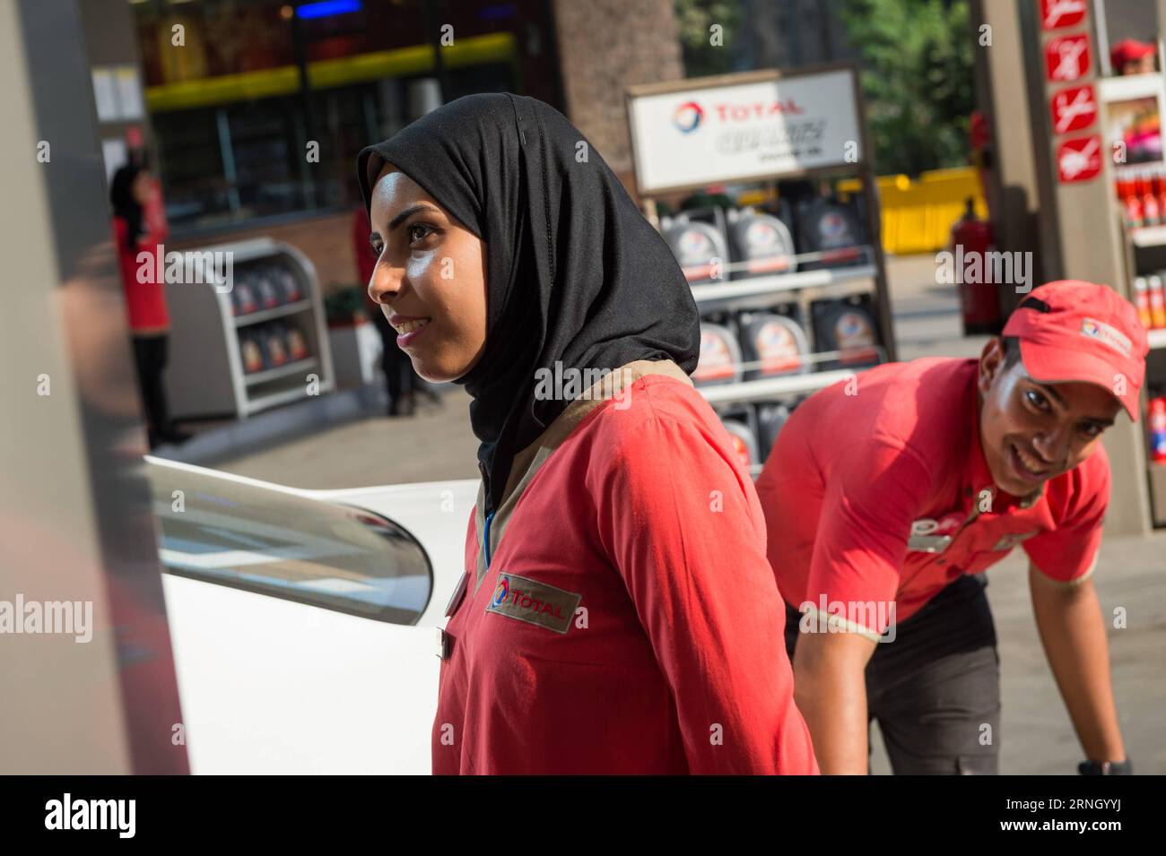 Ägypten - Weibliche Arbeitskräfte an einer Tankstelle in Kairo (161018) -- CAIRO, Oct. 18, 2016 -- Female and male employees work together at a gas station in Maadi district of Cairo, Egypt, Oct. 17, 2016. Dressed in red buttonless shirt and black pants uniform, 24-year-old veiled Hadeer Ashraf looked confident and swift while holding the fuel pump nozzle gun to serve the vehicles lined up at Total gas station near the Nile Corniche Street in Maadi district southwestern the Egyptian capital city of Cairo. ) (yk) EGYPT-CAIRO-GAS STATION-FEMALE WORKERS MengxTao PUBLICATIONxNOTxINxCHN   Egypt Fem Stock Photo