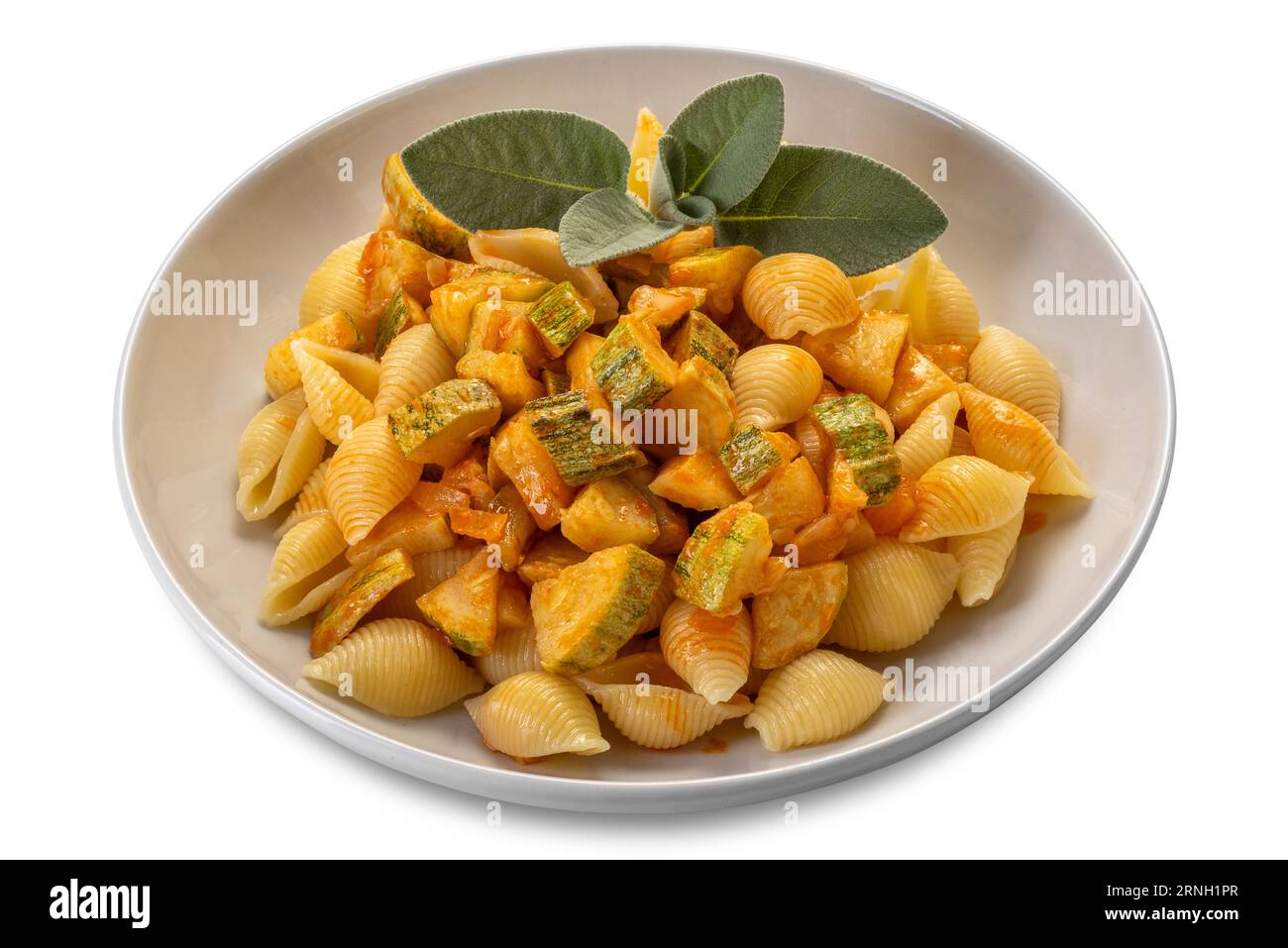 Conchiglie rigate pasta. Macaroni in shape of ridged shell with courgette and tomato sauce with sage leaves in white dish isolated on white with clipp Stock Photo