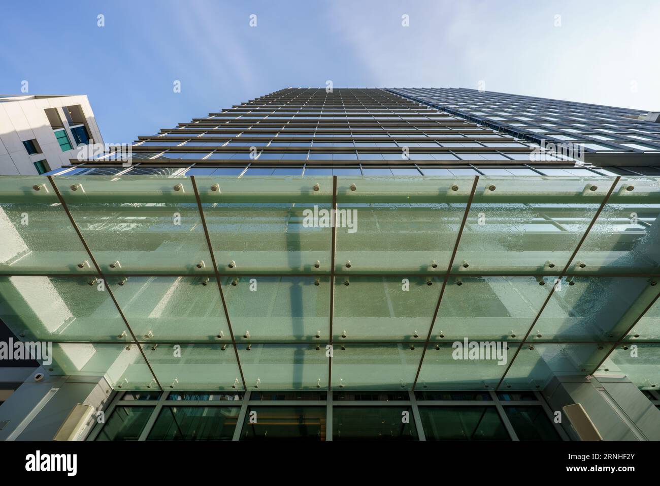Low angle office building with glass overhand metal frame support Stock Photo