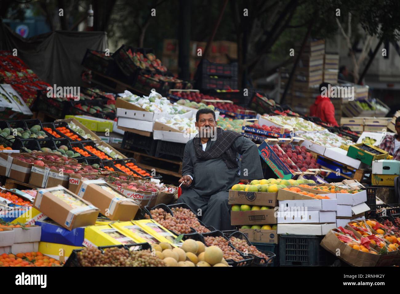 Fruit vendor waits customers market hi-res stock photography