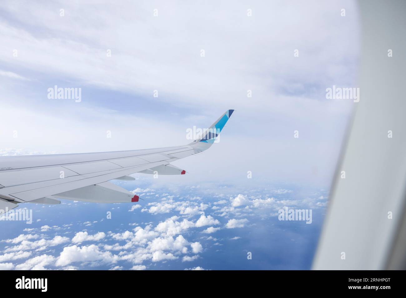 Wing of an airplane flying in the blue sky with white clouds Stock ...