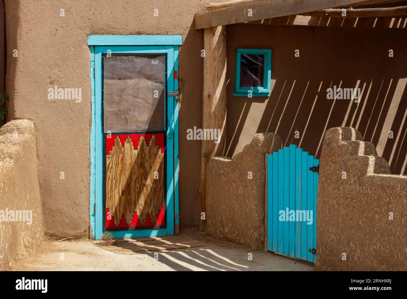 Decarative door at the Taos Pueblo built by the Tiwa tribe and is one of the oldest continuously inhabited places in the US - New Mexico Stock Photo