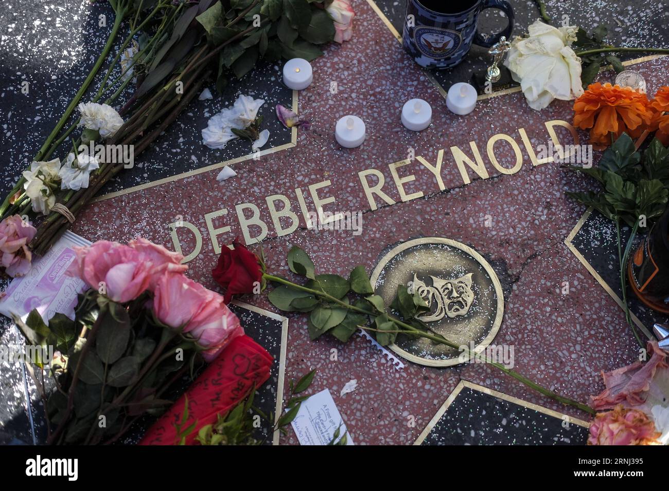 LOS ANGELES, Dec. 29, 2016 -- Flowers and candles surround the Hollywood Walk of Fame star of Debbie Reynolds, in Los Angeles, California, the United States, on Dec. 29, 2016. Hollywood star Debbie Reynolds died of stroke Wednesday at the age of 84, one day after her daughter Carrie Fisher s death. Carrie Fisher, the actress best known as Princess Leia in the Star Wars movie franchise, died at the age of 60 on Tuesday morning, after suffering a heart attack on a flight last Friday. ) (zw) U.S.-LOS ANGELES-DEBBIE REYNOLDS-CARRIE FISHER-WALK OF FAME-CONDOLENCE ZhaoxHanrong PUBLICATIONxNOTxINxCHN Stock Photo
