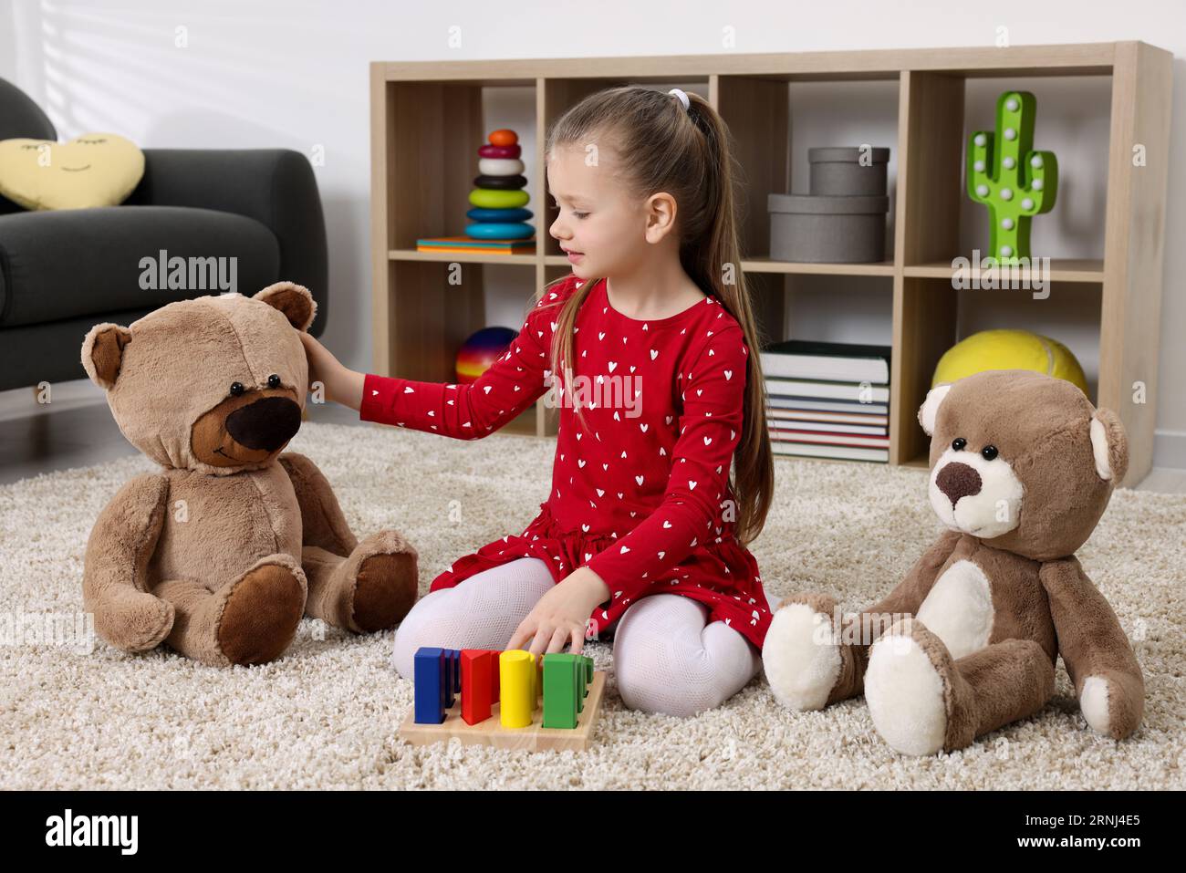 Teddy Playing Cute little girl playing with teddy bears and cubes at home Stock Photo ...