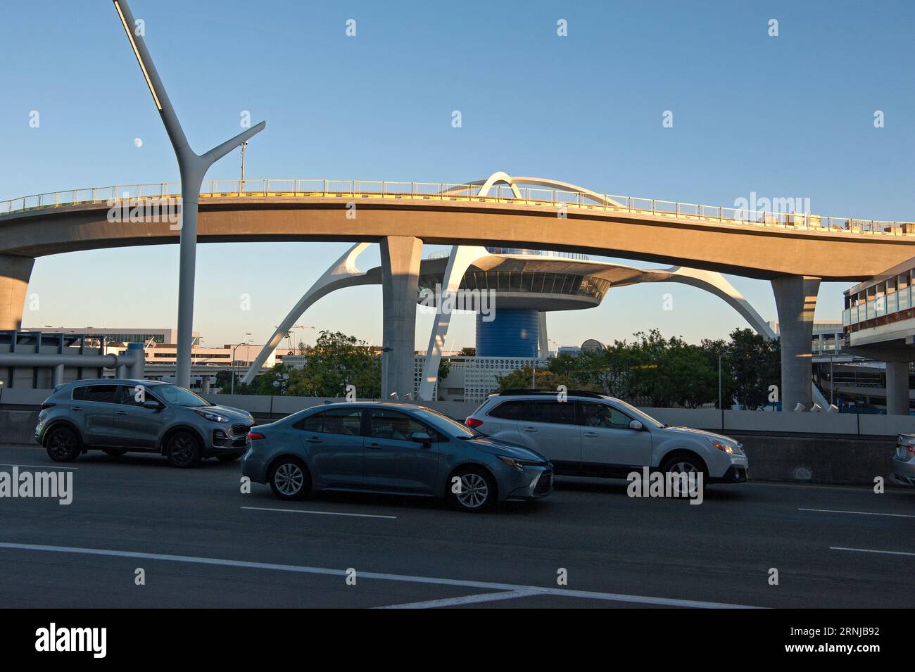 A newly added metro rail track coming into LAX partially obscures the view of the iconic Theme Building, Los Angeles, California, USA Stock Photo