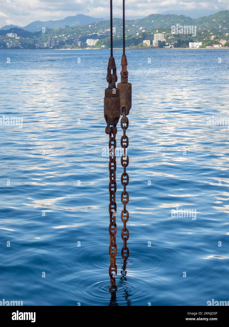 Powerful metal chain going into the water. Deep sea work. An industrial  tool lowered into the depths of the sea. Anchor concept Stock Photo - Alamy