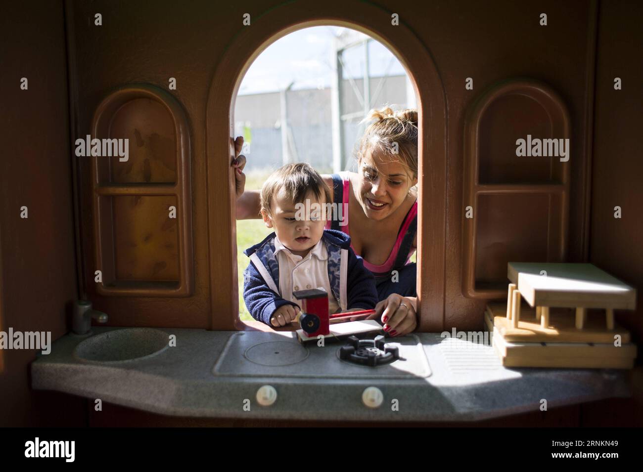 (170413) -- FLORENCIO VARELA, April 13, 2017 -- Nancy Oliver Ledezma (R) and her one-year-old son Timoteo (L) play in the yard of the house which they share with three women inmates and their children in the Criminal Unit 54 as part of the pilot program Houses for women with children in Florencio Varela city, Argentina, on April 12, 2017. The pilot program launched by the Justice Ministry in Buenos Aires province seeks to improve the life quality of the women inmates that live with their children. The program offerd small houses inside a prison complex so that the children may avoid the impact Stock Photo