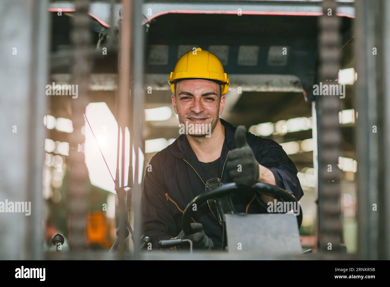 Portrait happy forklift driver wearing safety helmet and vest enjoy working transporting goods in warehouse shipping cargo Stock Photo