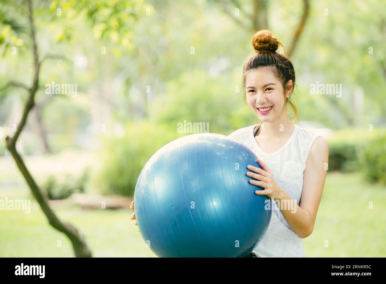 beautiful asian happy woman play enjoy fun with fit ball exercise at park outdoor slim and healthy girl workout activity. Stock Photo