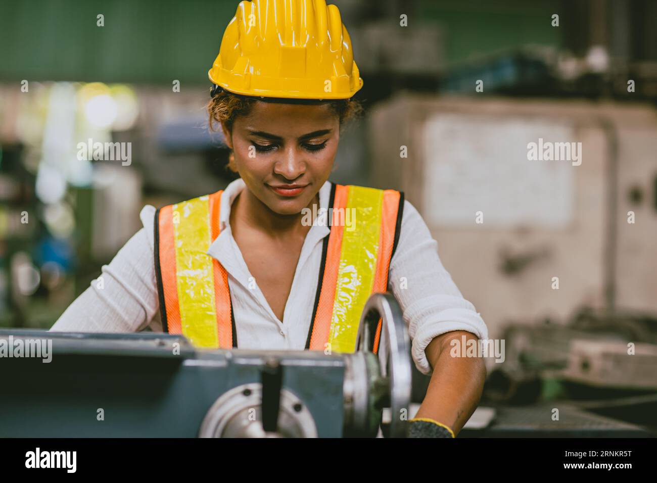 African engineer technician woman black skin in safety uniform enjoy happy working metal lathe milling production process in heavy industry Stock Photo