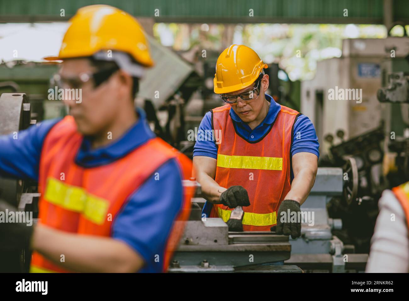 Asian expert technician engineer male focus detail working precision manual cut lathe milling metal production in heavy industry Stock Photo