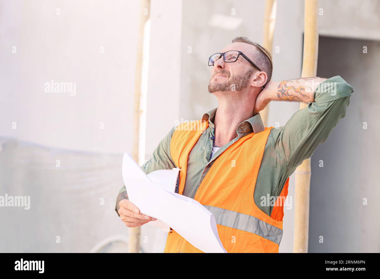 senior engineer worker hard work tired neck strain painful from muscle cramp injury during work in construction site Stock Photo