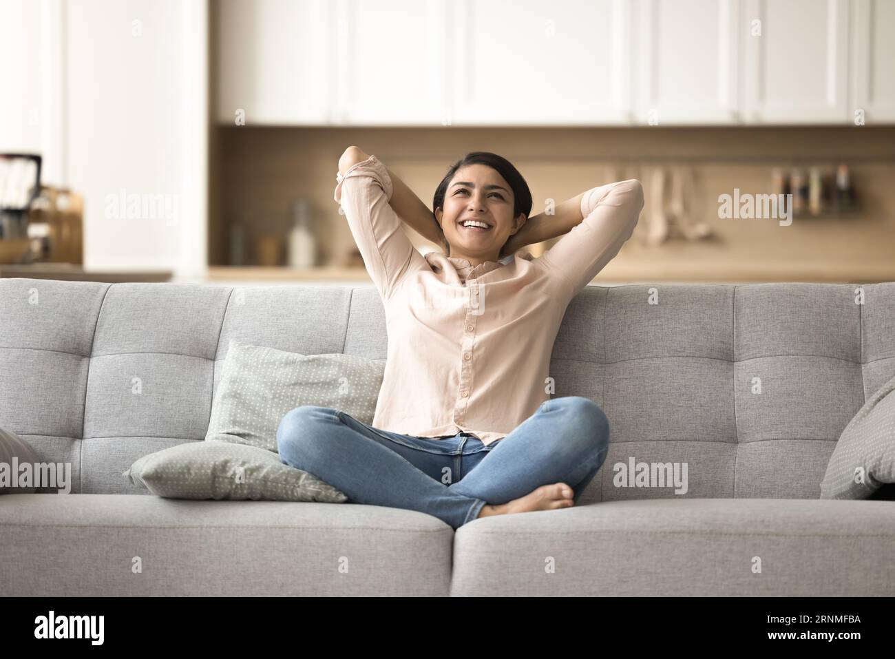 Positive beautiful Indian woman relaxing on soft couch Stock Photo - Alamy