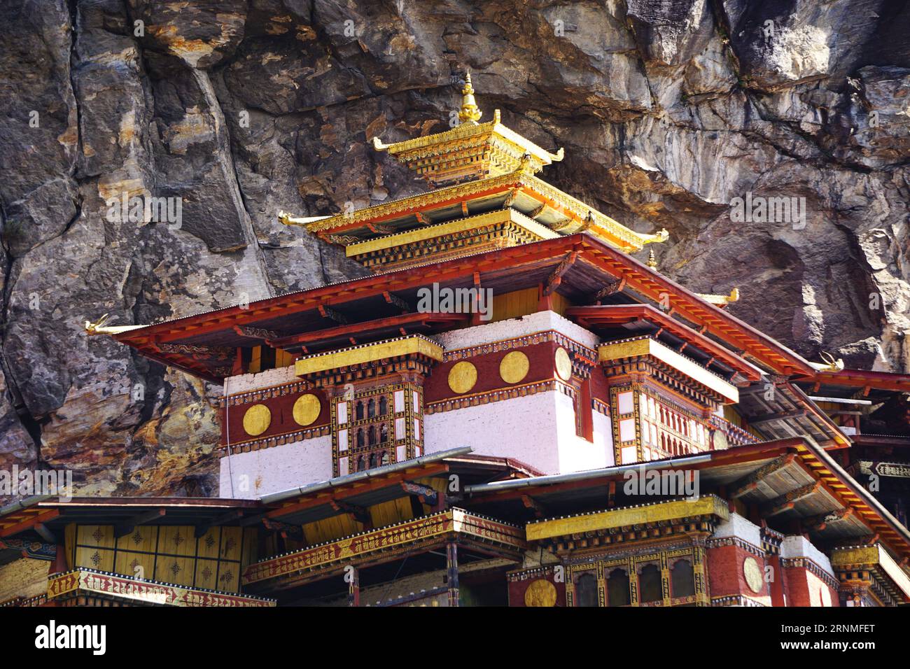 Closeup detail of the Tiger's Nest Monastery showing its gilded square pagoda rooftop and traditional intricately painted woodwork, near Paro, Bhutan Stock Photo