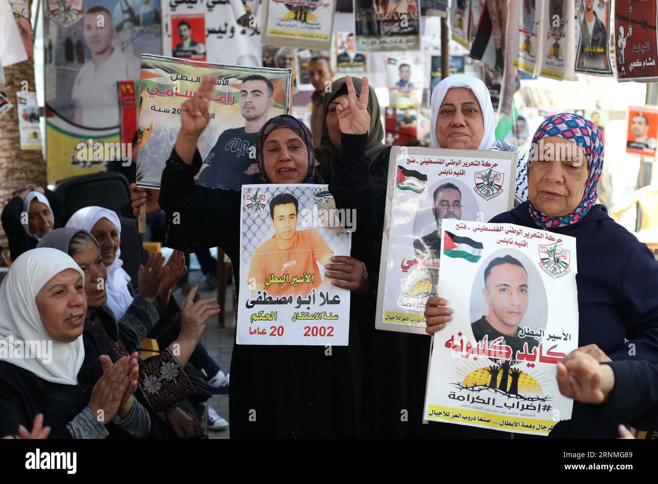 (170527) -- NABLUS, May 27, 2017 -- Palestinian women hold pictures of their jailed families, as they celebrate during a protest in solidarity with prisoners in Israeli jails, in the West Bank City of Nablus, on May 27, 2017. Palestinian Fatah Party Recruitment Commissioner Jamal Muheisen declared that over 1,500 Palestinian prisoners in Israeli jails have suspended their hunger strike after a deal with the Israeli Prisons Authority. )(yk) MIDEAST-NABLUS-PRISONERS AymanxNobani PUBLICATIONxNOTxINxCHN   Nablus May 27 2017 PALESTINIAN Women Hold Pictures of their jailed families As They Celebrate Stock Photo