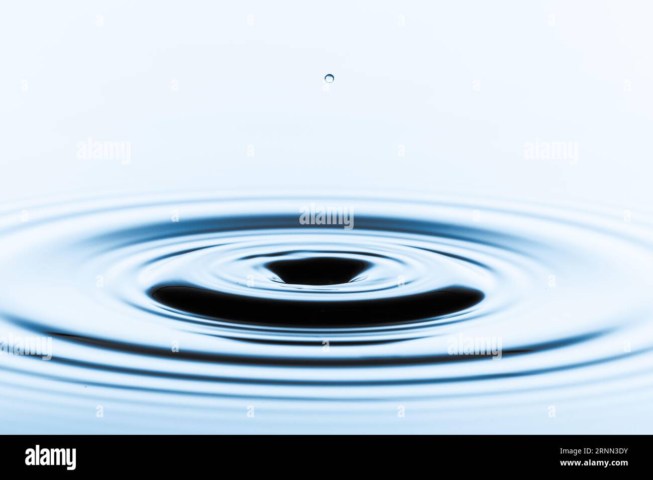 Water Purity: Portray the purity of a single water droplet's entry into the pristine water. Stock Photo