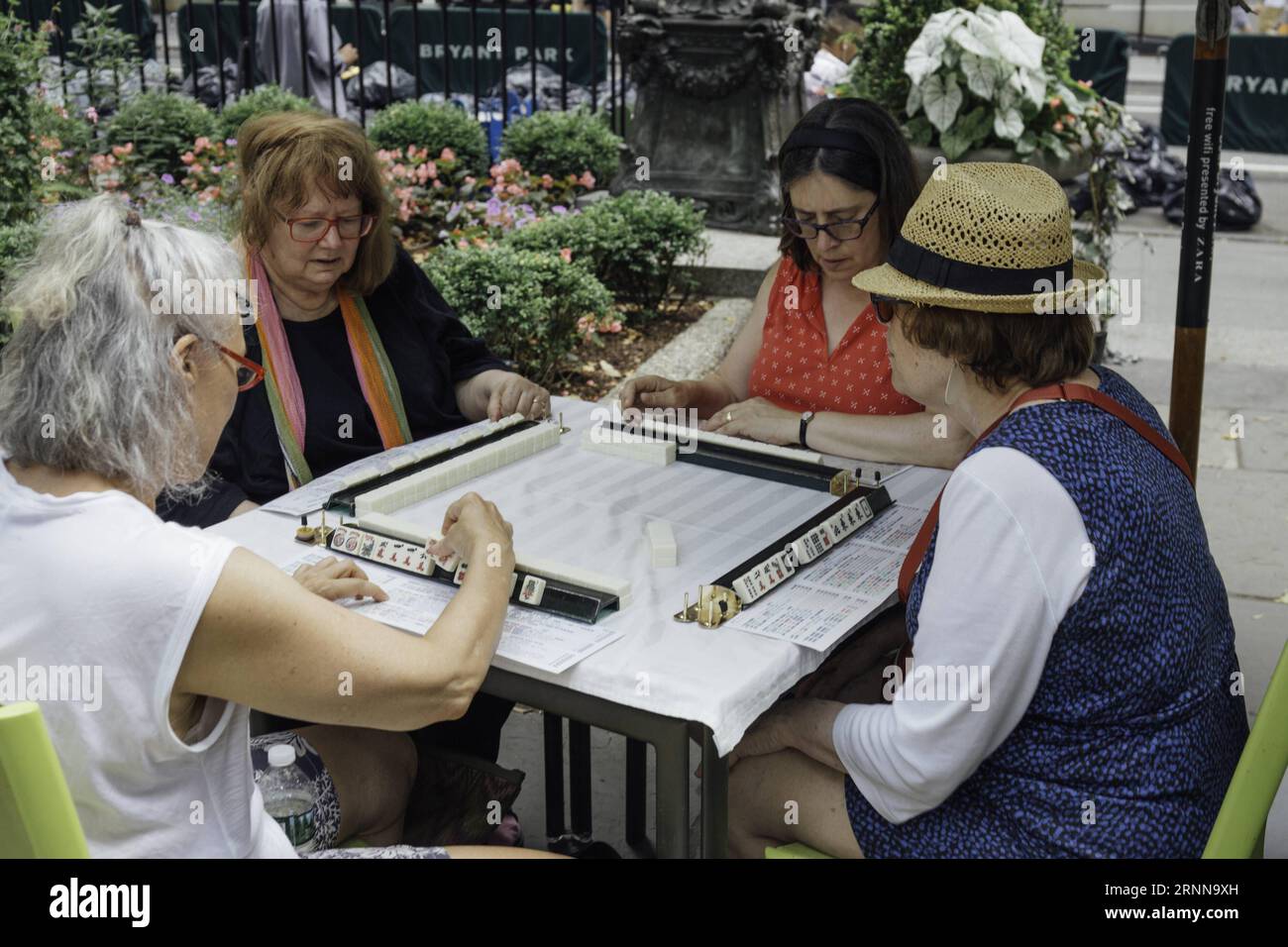 (170703) -- NEW YORK, July 3, 2017 -- Hobbyists play Mah Jongg during the Mah Jongg Marathon event at Bryant Park in New York City, the United States, on July 3, 2017. According to event organizer Linda Fisher, the event is organized to provide a place for Mah Jongg hobbyists to communicate with each other and promote the game to more people. Mah Jongg, originated from China, was introduced to the United States in the 1920s. ) U.S.-NEW YORK-MAH JONGG MARATHON XuxKeshuang PUBLICATIONxNOTxINxCHN   New York July 3 2017 hobbyists Play Mah Jongg during The Mah Jongg Marathon Event AT Bryant Park in Stock Photo