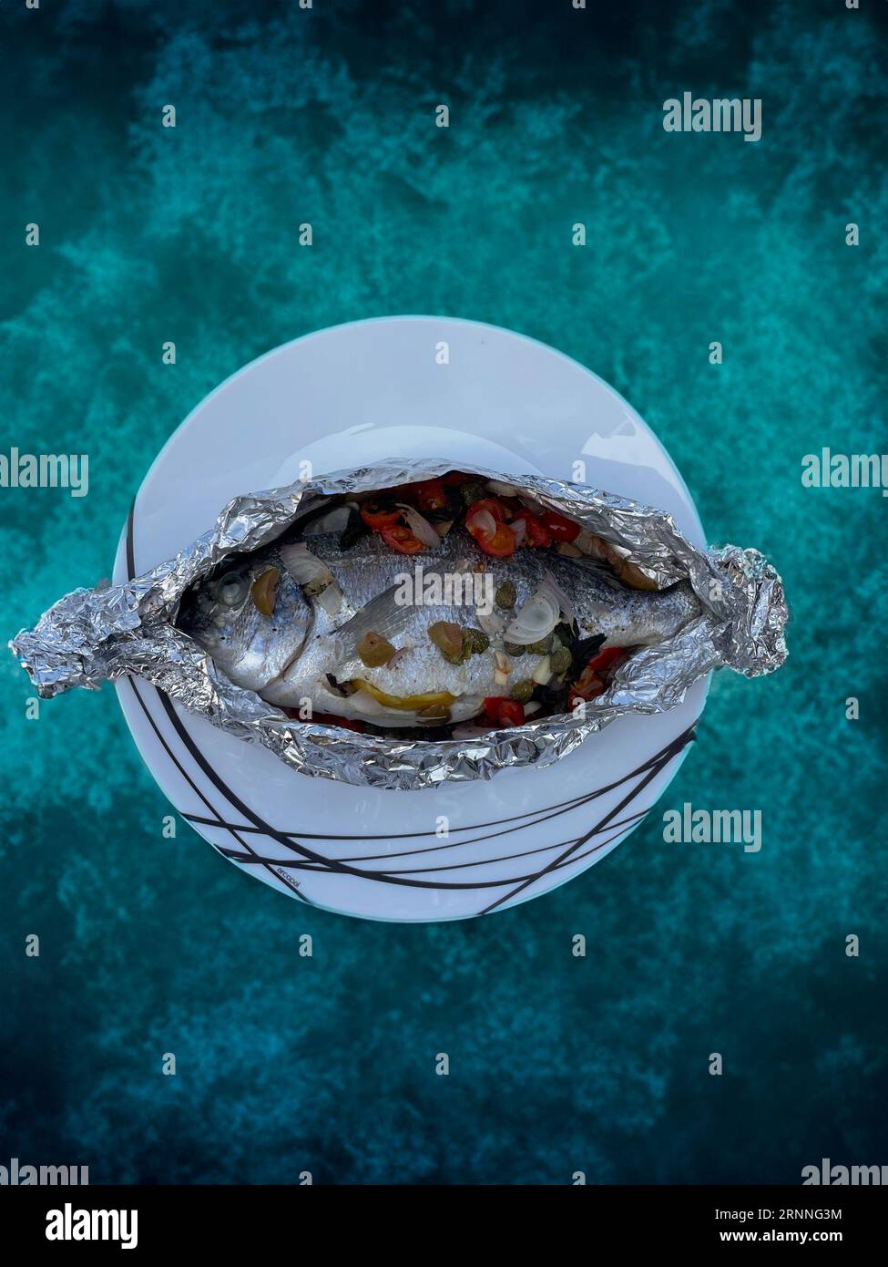 baked sea bream with capers cherry tomatoes onion and lemon ready for