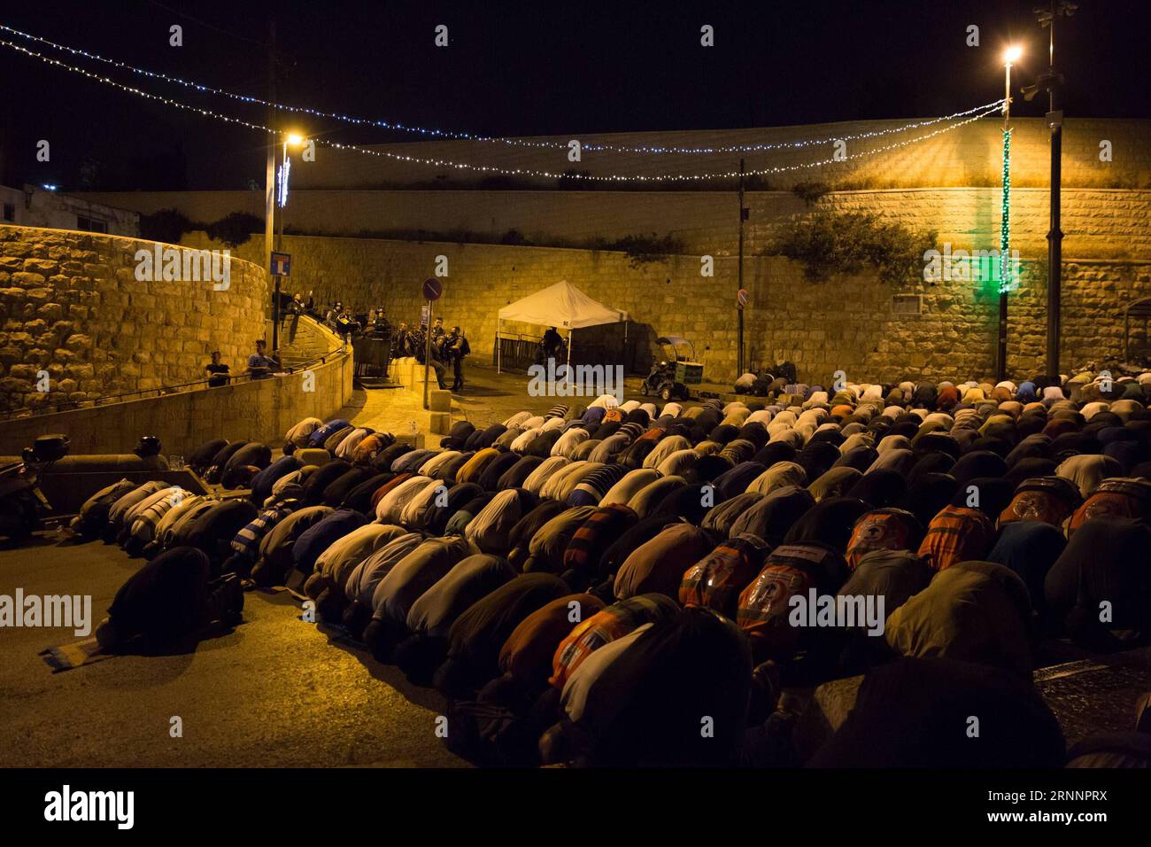 (170725) -- JERUSALEM, July 25, 2017 -- Muslims pray outside Lion s Gate of Jerusalem s Old City, July 25, 2017. Israel s Security Cabinet has decided to remove metal detectors from the entrance to the holy site in Jerusalem which is known as the Noble Sanctuary to Muslims and Temple Mount to Jews, and to take security measures based on advanced technologies ( smart checks ) instead, according to a statement issued by the Prime Minister s Office on Tuesday morning. ) (zjy) MIDEAST-JERUSALEM-AL-AQSA MOSQUE COMPOUND-METAL DETECTOR-REMOVAL GuoxYu PUBLICATIONxNOTxINxCHN   Jerusalem July 25 2017 Mu Stock Photo