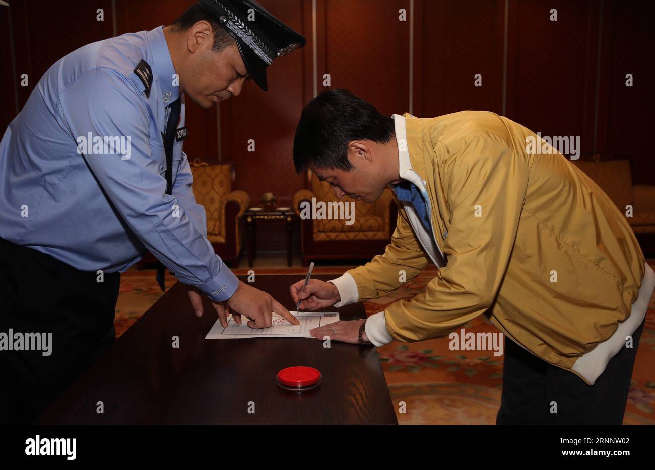 (170729) -- BEIJING, July 29, 2017 -- Ren Biao (R) signs on his arrest warrant at Beijing Capital International Airport in Beijing, capital of China, July 29, 2017. Ren Biao, one of China s most wanted fugitives, has returned to China and turned himself in to the police, the anti-corruption authority said Saturday. Ren, 44, former actual controlling shareholder of Daluo energy supplies company in east China s Jiangsu Province, fled to the Caribbean nation of Saint Kitts and Nevis in January 2014 after being accused of fraudulently obtaining loans and fabricating financial bills, according to a Stock Photo