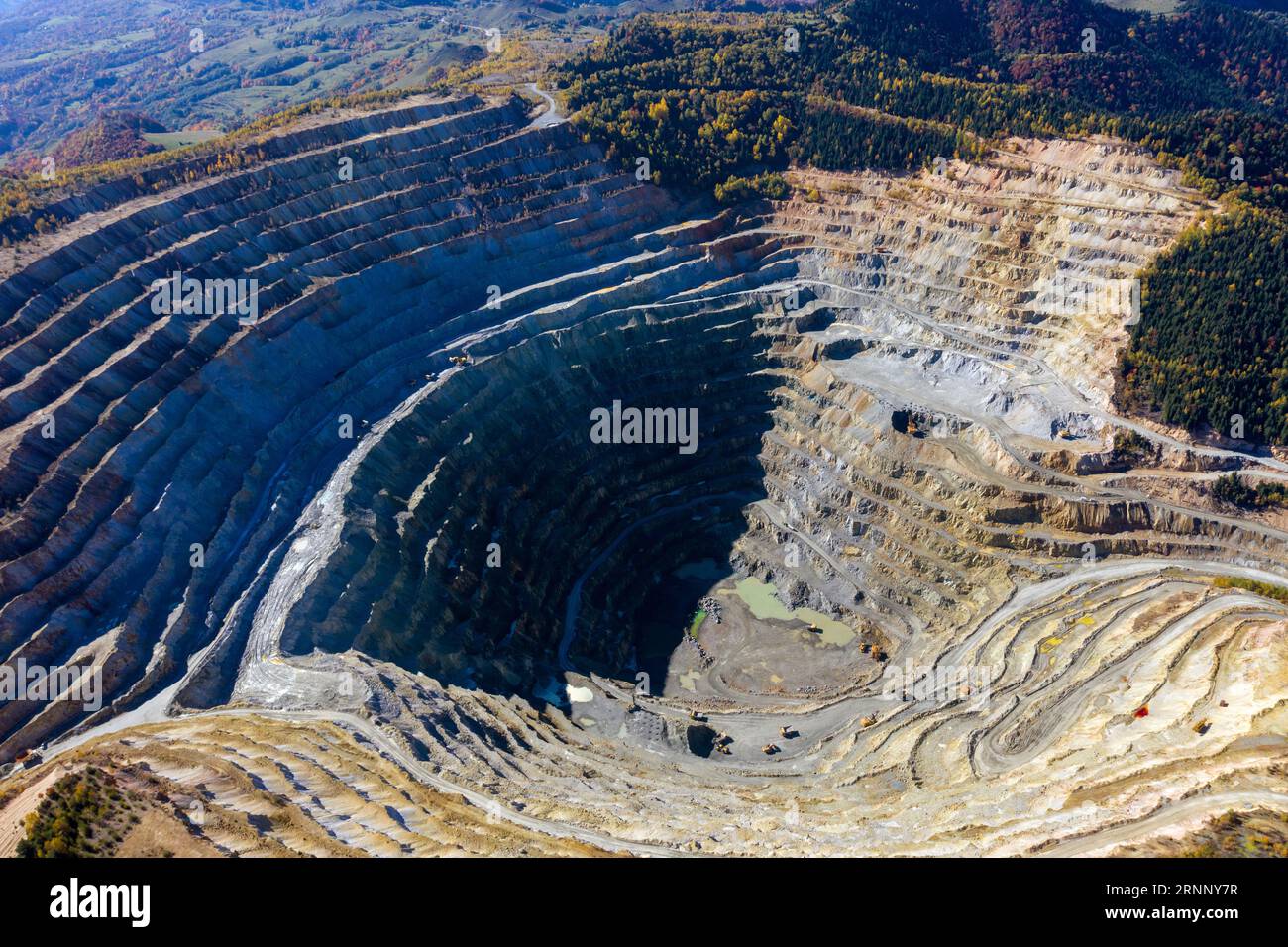 Flying above an open pit mine, copper excavation in Rosia Poieni, Romania. Aerial drone view Stock Photo