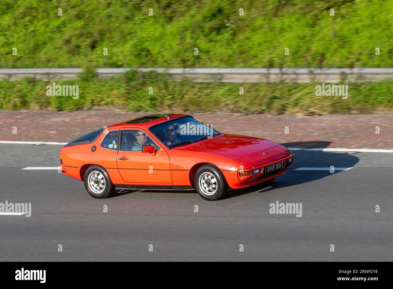 1978 70s seventies Red Porsche 924 Petrol 1984 cc travelling at speed on the M6 motorway in Greater Manchester, UK Stock Photo