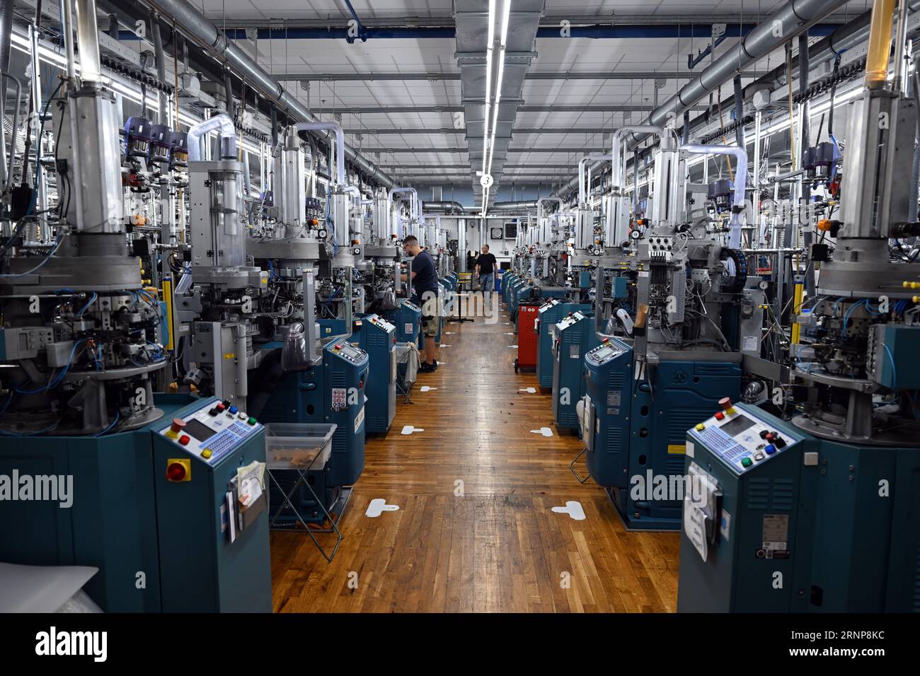 01 September 2023, North Rhine-Westphalia, Schmallenberg: Knitting machines  stand in a production hall at Falke