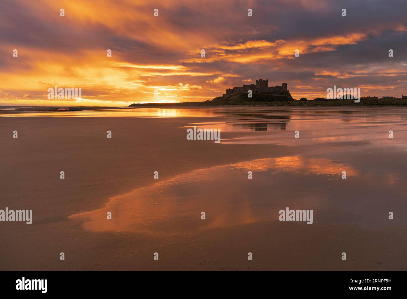 Bamburgh Castle from Bamburgh beach at sunrise, Northumberland, UK Stock Photo