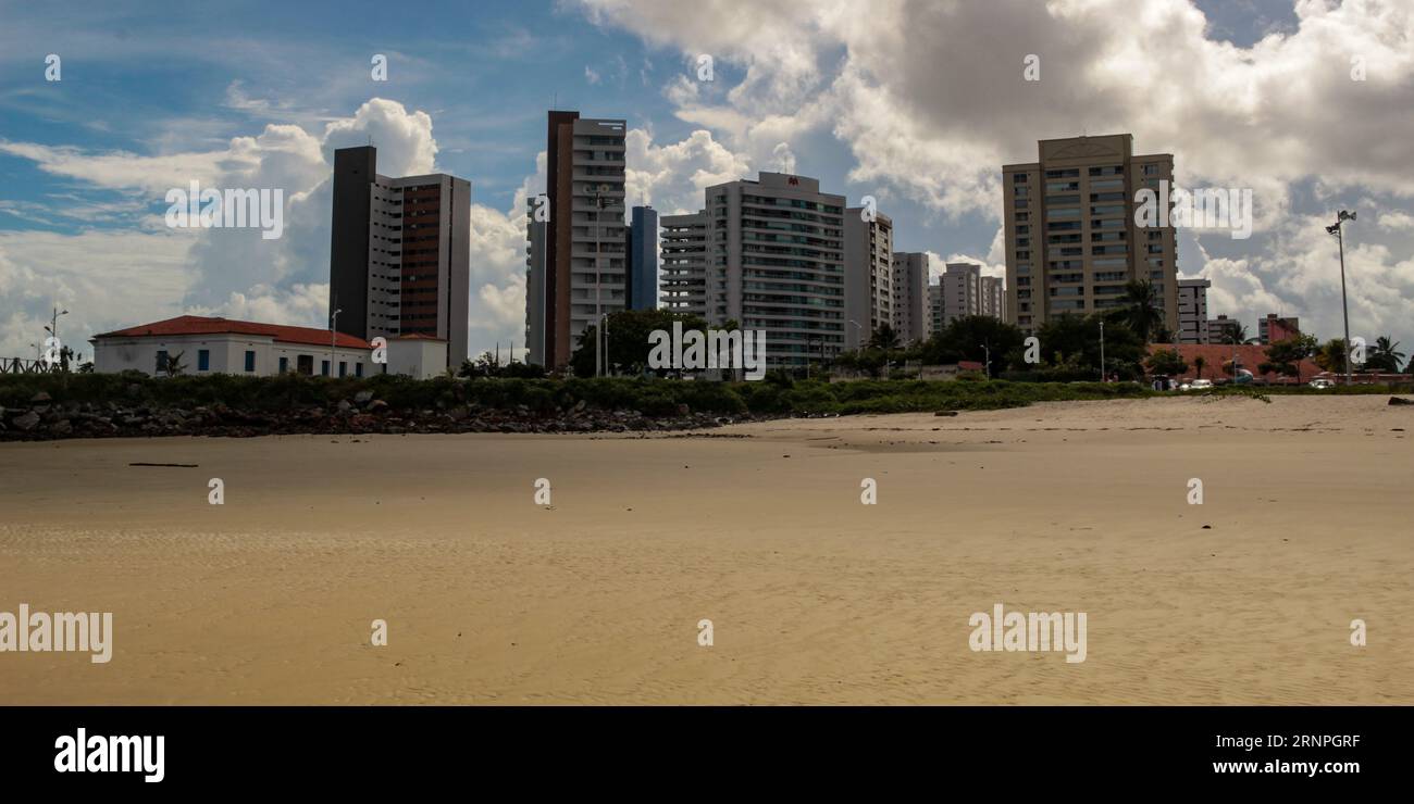 Ponta D'areia beach, with the historic Santo Antonio fort and modern apartment buildings, in the background the blue sky with white clouds Stock Photo