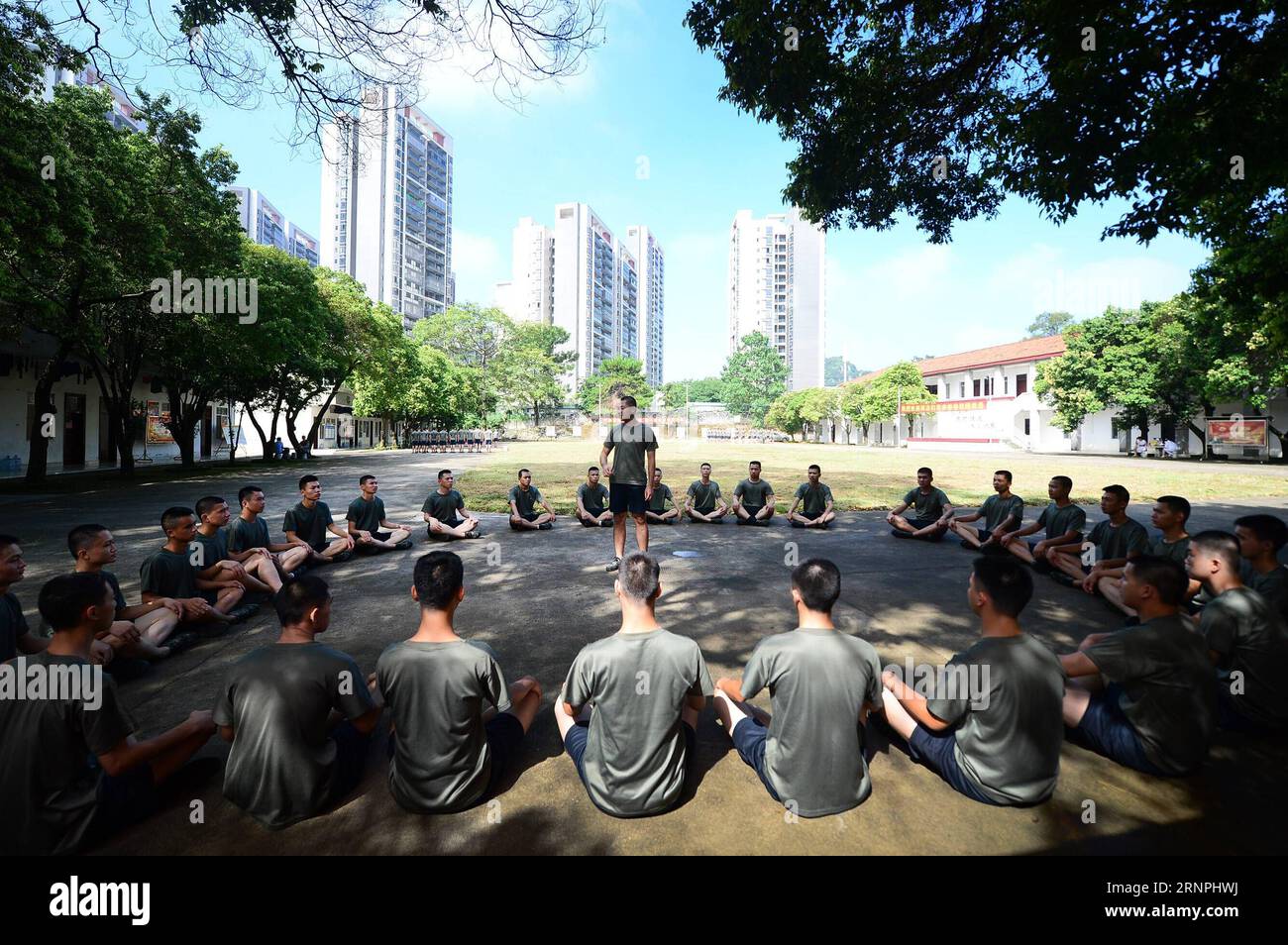 (170830) -- LIUZHOU, Aug. 30, 2017 -- Deng Feng (C) tells his former experience in the army during a training in Liuzhou, south China s Guangxi Zhuang Autonomous Region, Aug. 30, 2017. Deng, 24, who just graduated from Xingjian College of Science and Liberal Arts of Guangxi University, has signed for the army twice. When he was a freshman, Deng Feng was for the first time recruited as a soldier of Guangxi Frontier Corps of Chinese Armed Police and was on service for two years. Deng Feng then left army and went back to Guangxi University until he finished his study. Upon graduation, however, De Stock Photo