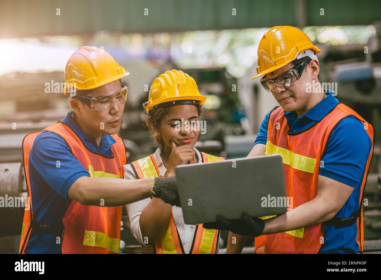 engineer team mix race man and woman working together in heavy industry with laptop computer discussion, join helping engineer teamwork. Stock Photo