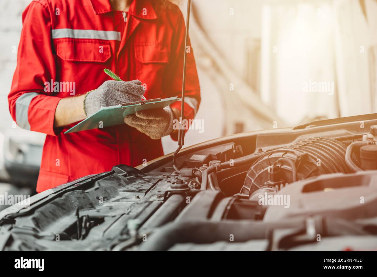 mechanic team check list engine repair maintenance oil liquid change at front hood of old car in auto service workshop Stock Photo