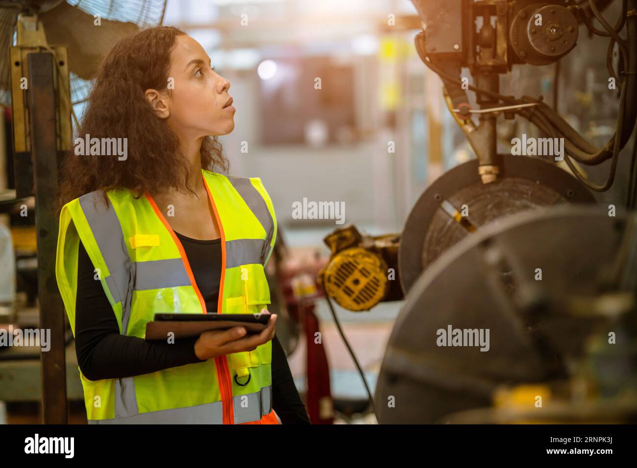 engineer smart woman african black worker check machine condition for safety service maintenance in heavy metal factory Stock Photo