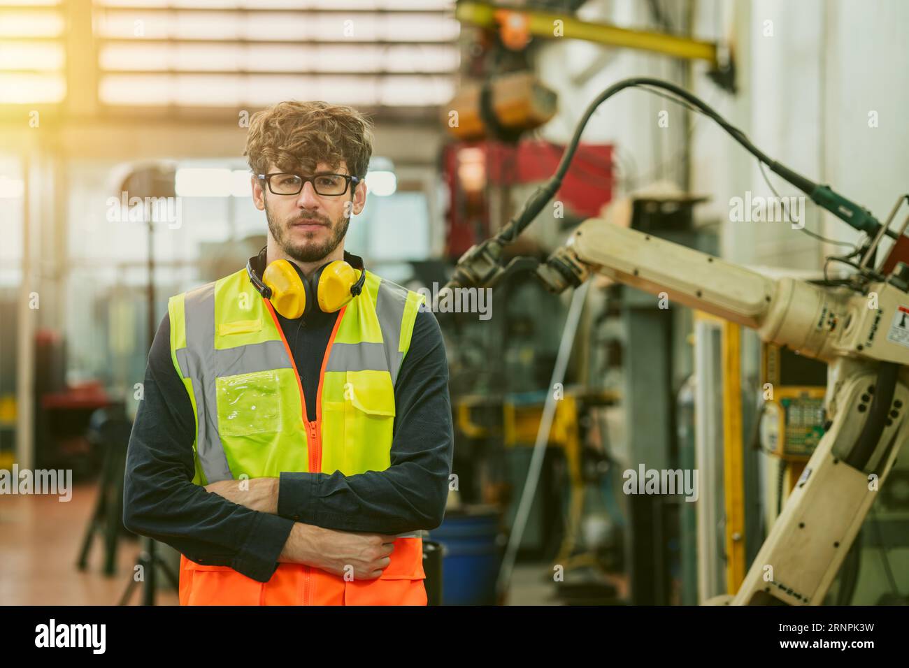 portrait smart young american engineer caucasion male work with automation machinery operator confident arm crossed Stock Photo