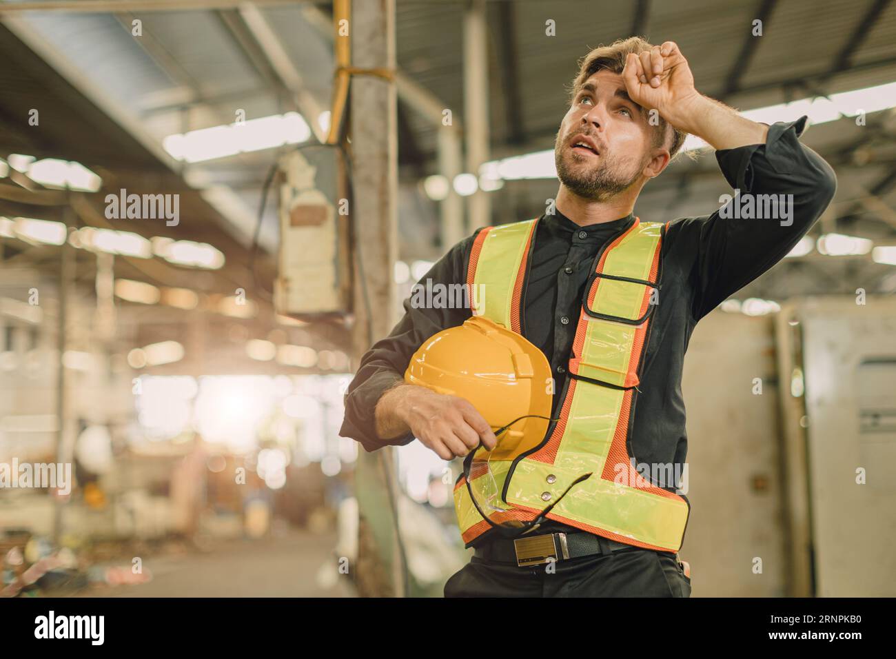 young engineer male caucasian worker tired exhausted fatigue from hard working in heavy industry machinery factory Stock Photo