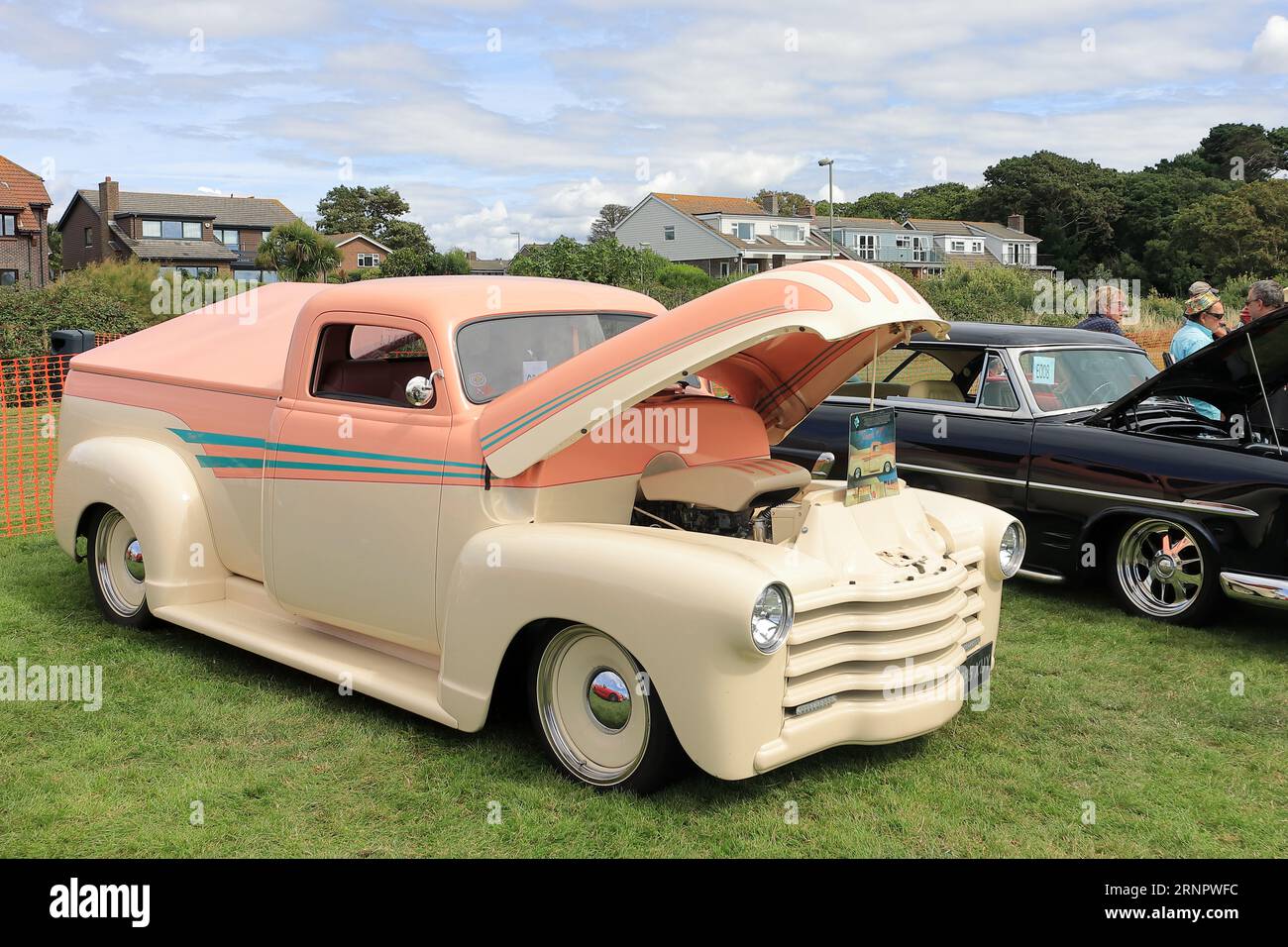 Peach 1940s Chevrolet 3100 truck on display. The Gosport Car Rally is organised by the local Rotary Club and takes place at Stokes Bay on the August bank holiday Monday. This year's event, providing a cheap family day out, was the seventieth and hosted vintage cars and motorbikes, a petting farm, stalls, refreshments and an arena which provided various forms of entertainment. Stock Photo